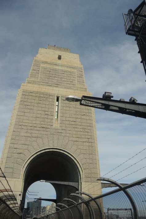 Having walked north-to-south across the enormous single span of Sydney Harbour Bridge, this pylon beckons us to see her views. One can climb all the way up the arch of the bridge to the highest point, but we opt not to spend that time or money.